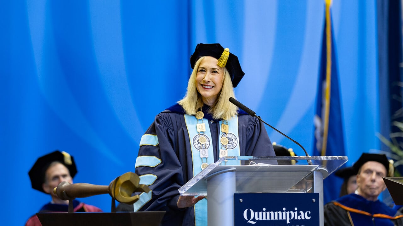 Marie Hardin smiling at the podium on the Inauguration stage